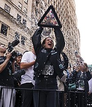 New York Liberty guard Sabrina Ionescu holds up the WNBA basketball championship trophy while riding down Broadway during a parade celebrating the team’s season championship, Thursday, Oct. 24, in New York.