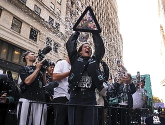 New York Liberty guard Sabrina Ionescu holds up the WNBA basketball championship trophy while riding down Broadway during a parade celebrating the team’s season championship, Thursday, Oct. 24, in New York.