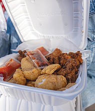 Sandra Tatum displays some of the food served at the block party. The menu featured Soul Food and Southern cuisine.