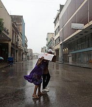People walk on a street as Hurricane Rafael passes over Havana on Wednesday.
Mandatory Credit:	Alexandre Meneghini/Reuters via CNN Newsource