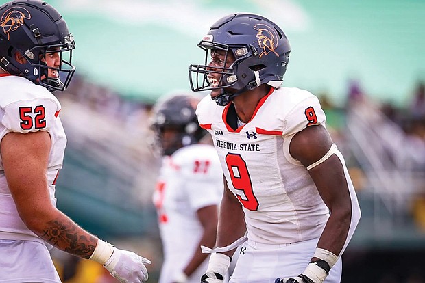 Defensive end Mustapha Coly and offensive lineman Gabe Navarro celebrate a key play during in a recent game.