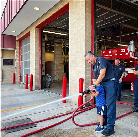 Firefighter Garcia at Station 23 with one of Councilmember Martinez's children.