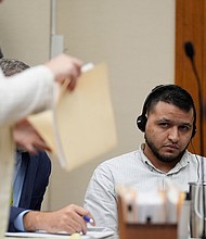 Defense attorney Kaitlyn Beck shuffles papers in a folder as Jose Ibarra, center, accused of killing nursing student Laken Riley, appears in court for a motion hearing in October.
Mandatory Credit:	Brynn Anderson/Pool/AP via CNN Newsource