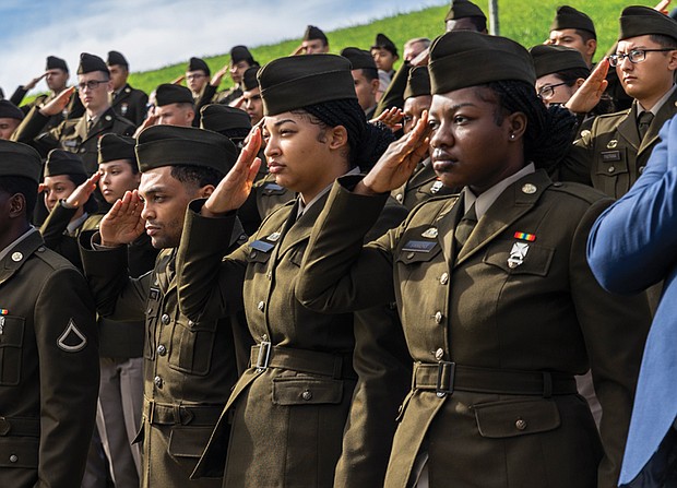 U.S. Army Golf Company, 244th Quartermaster Battalion members Genesis Simmons, right, Mary Hagy, and Keith Pirtle salute the flag during the national anthem.