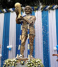 People shower petals on Diego Maradona's statue in Kolkata during a prayer meeting to pay tribute to him after his death in November 2020.
Mandatory Credit:	Rupak De Chowdhuri/Reuters via CNN Newsource