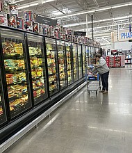 A lone shopper places items in her cart in the frozen food aisle of a Walmart store on November 14, in Englewood, Colorado. Walmart keeps growing with shoppers making more than $100,000 a year.
Mandatory Credit:	David Zalubowski/AP via CNN Newsource