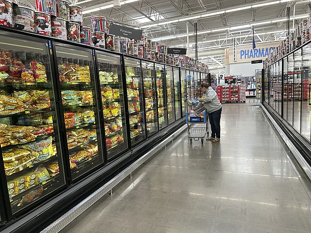 A lone shopper places items in her cart in the frozen food aisle of a Walmart store on November 14, in Englewood, Colorado. Walmart keeps growing with shoppers making more than $100,000 a year.
Mandatory Credit:	David Zalubowski/AP via CNN Newsource
