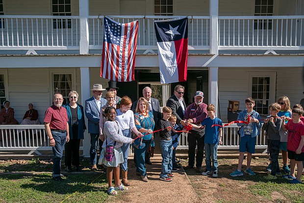 Anderson Mayor Marc Benton, center, helps cut the ribbon on Fanthorp Inn State Historic Site on Friday, Nov. 15, in Anderson. (Patrick Hughey | Texas Historical Commission)
