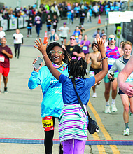 Londyn Jackson, 14, celebrates with her sister, Sydney Jackson, 10, after crossing the finish line of the VCU Health Richmond 8K on Saturday, Nov. 16. Londyn finished with a time of 45:32, earning a top spot in her age group.