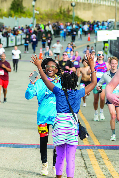 Londyn Jackson, 14, celebrates with her sister, Sydney Jackson, 10, after crossing the finish line of the VCU Health Richmond 8K on Saturday, Nov. 16. Londyn finished with a time of 45:32, earning a top spot in her age group.