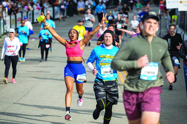 Enuma Iyob celebrates Saturday, Nov. 16, as she crosses the finish line of the CarMax Richmond Half Marathon.