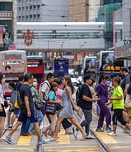 Pedestrians cross a street in Hong Kong on June 25.
Mandatory Credit:	Paul Yeung/Bloomberg/Getty Images via CNN Newsource