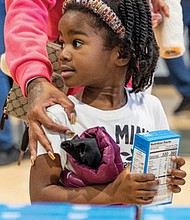Maleah Harris, 4, carries a box of cornbread mix during the 6th Annual Thanksgiving Turkey Giveaway and Resource Fair on Nov. 23 at River City Middle School, 6300 Hull Street Road.
State Delegate Mike Jones, alongside leaders from Rosie’s and Churchill Downs, distributed 2,000 turkeys to Richmond residents, while Virginia Sen. Ghazala Hashmi and her team handed out over a thousand boxes of cornbread mix.