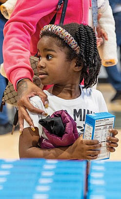 Maleah Harris, 4, carries a box of cornbread mix during the 6th Annual Thanksgiving Turkey Giveaway and Resource Fair on Nov. 23 at River City Middle School, 6300 Hull Street Road.
State Delegate Mike Jones, alongside leaders from Rosie’s and Churchill Downs, distributed 2,000 turkeys to Richmond residents, while Virginia Sen. Ghazala Hashmi and her team handed out over a thousand boxes of cornbread mix.