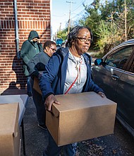 Rose Bolling helps distribute Thanksgiving meals at Trinity Baptist Church in Richmond’s North Side on Saturday, Nov. 23. Meals were handed out curbside behind the church. Along with boxes of groceries for a Thanksgiving meal, recipients received gift cards to purchase a turkey or other items of their choice.