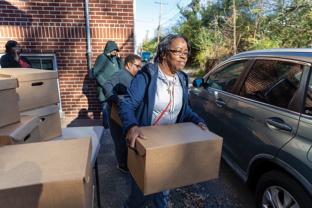 Rose Bolling helps distribute Thanksgiving meals at Trinity Baptist Church in Richmond’s North Side on Saturday, Nov. 23. Meals were handed out curbside behind the church. Along with boxes of groceries for a Thanksgiving meal, recipients received gift cards to purchase a turkey or other items of their choice.