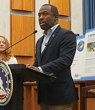From left, Institute for Sustainable Infrastructure President and CEO Anthony Kane and Office of Sustainability Director Laura Thomas look on as Mayor Levar M. Stoney shares updates on the city’s RVA Green 2050 plan Friday at City Hall.