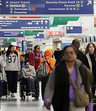 Travelers walk through Terminal 3 at O’Hare International Airport Nov. 26 in Chicago.