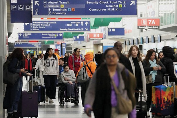 Travelers walk through Terminal 3 at O’Hare International Airport Nov. 26 in Chicago.