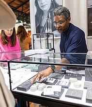 Cindy Liebel, jewelry designer and metalsmith, speaks with an attendee at her booth during the Visual Arts Center of Richmond’s 60th Annual Contemporary Craft Show, Craft + Design, on Nov. 23, at Main Street Station. Celebrating 60 years, the event is known for featuring museum-
quality pieces.