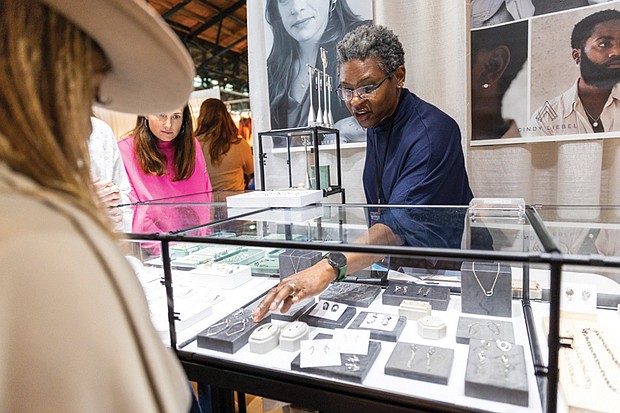 Cindy Liebel, jewelry designer and metalsmith, speaks with an attendee at her booth during the Visual Arts Center of Richmond’s 60th Annual Contemporary Craft Show, Craft + Design, on Nov. 23, at Main Street Station. Celebrating 60 years, the event is known for featuring museum-
quality pieces.