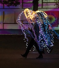 Hallie Wilson and her father, Mark Wilson, walk in the Community Lantern Parade dressed in illuminated jellyfish costumes.