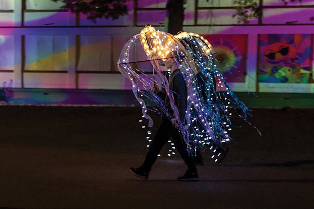 Hallie Wilson and her father, Mark Wilson, walk in the Community Lantern Parade dressed in illuminated jellyfish costumes.