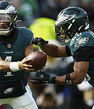 Philadelphia Eagles quarterback Jalen Hurts (1) hands off to Philadelphia Eagles running back Saquon Barkley (26) during the first half of a game against the Carolina Panthers on Sunday, Dec. 8, in Philadelphia.