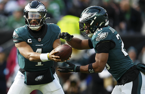 Philadelphia Eagles quarterback Jalen Hurts (1) hands off to Philadelphia Eagles running back Saquon Barkley (26) during the first half of a game against the Carolina Panthers on Sunday, Dec. 8, in Philadelphia.