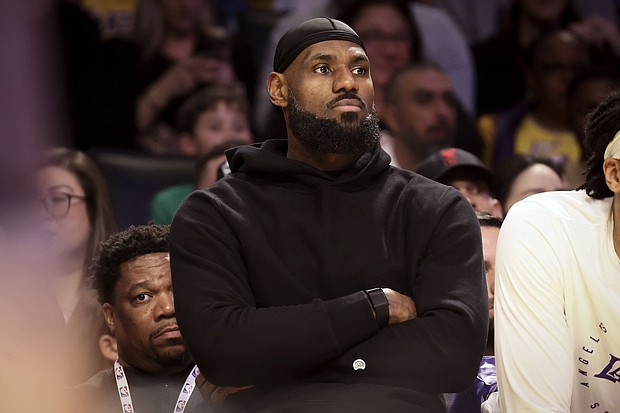 Los Angeles Lakers forward LeBron James watches from the bench during the first half of Sunday's game against the Portland Trail Blazers.
Mandatory Credit:	Etienne Laurent/AP via CNN Newsource