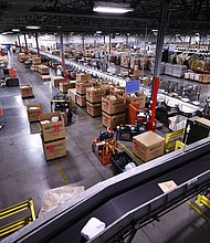 US Postal Service employees work inside the Los Angeles Mail Processing & Distribution Center on December 3. The facility is currently processing 1 million packages per day.
Mandatory Credit:	Mario Tama/Getty Images via CNN Newsource
