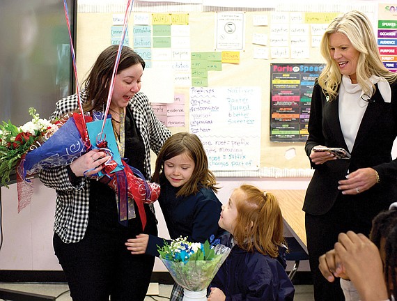 Henrico County Teacher of the Year Christine Suders is congratulated by her daughters at Hermitage High School, as Amy Cashwell, Henrico County Public Schools superintendent, looks on.