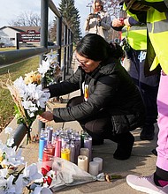 A resident places some flowers outside the Abundant Life Christian School on Tuesday, December 17.
Mandatory Credit:	Morry Gash/AP via CNN Newsource
Dateline: