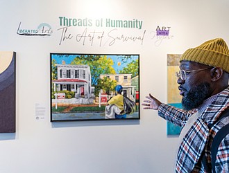 David Marion, visual artist and co-founder of the Liberated Arts Foundation, discusses one of his pieces in the pop-up exhibition “Threads of Humanity: The Art of Survival” at the Black History Museum & Cultural Center of Virginia. Curated by Marion and his wife, Tiara Green, the exhibit focuses on homelessness, with a portion of art sales supporting organizations that aid unhoused individuals.