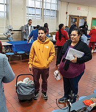 Husband and wife Gerardo and Gabriela Estrada attend Financial Literacy Night at Swansboro Elementary School in Richmond’s South Side on Thursday, Dec. 12, where they listen to Angela McNeal, of Angela’s Fashion Mix, with the help of a translator.