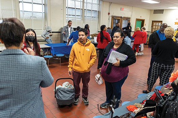 Husband and wife Gerardo and Gabriela Estrada attend Financial Literacy Night at Swansboro Elementary School in Richmond’s South Side on Thursday, Dec. 12, where they listen to Angela McNeal, of Angela’s Fashion Mix, with the help of a translator.