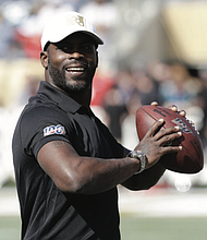 Former NFL quarterback Michael Vick smiles while warming up before the NFL Pro Bowl in January 2020, in Orlando, Fla.