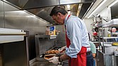 Gov. Glenn Youngkin prepares to serve pancakes to guests Dec. 16 at McLean’s Restaurant, following the announcement of a proposal to eliminate taxes on tipped income.