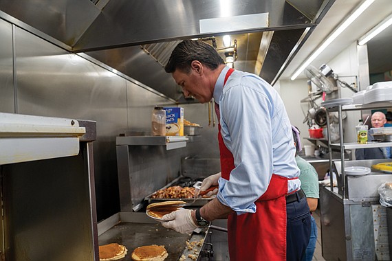 Gov. Glenn Youngkin prepares to serve pancakes to guests Dec. 16 at McLean’s Restaurant, following the announcement of a proposal to eliminate taxes on tipped income.