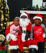 Sharing holiday cheer-Amira, 2, and Caleel, 4, take a photo with Soul Santa at the Black History Museum of Virginia on Saturday, Dec. 7. The museum welcomed children and families to enjoy a festive day of activities, including Christmas stories, arts and crafts, and a chance to meet the
iconic Soul Santa. While Soul Santa has returned home, some experts suggest that children might want to keep up their good behavior — just in case!   Julianne Tripp HIllian/Richmond Free Press