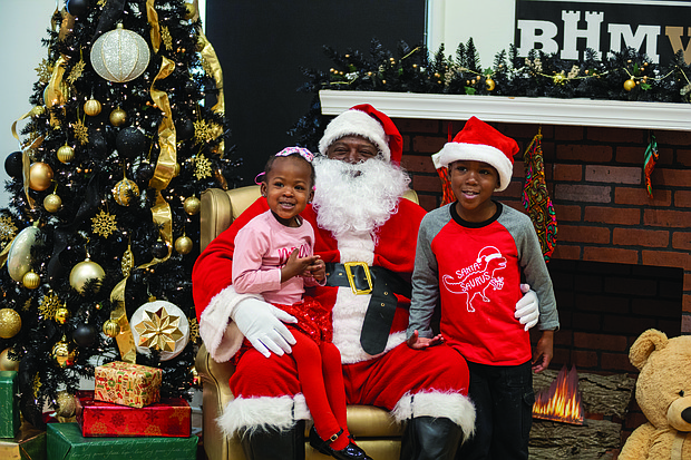 Sharing holiday cheer-Amira, 2, and Caleel, 4, take a photo with Soul Santa at the Black History Museum of Virginia on Saturday, Dec. 7. The museum welcomed children and families to enjoy a festive day of activities, including Christmas stories, arts and crafts, and a chance to meet the
iconic Soul Santa. While Soul Santa has returned home, some experts suggest that children might want to keep up their good behavior — just in case!   Julianne Tripp HIllian/Richmond Free Press