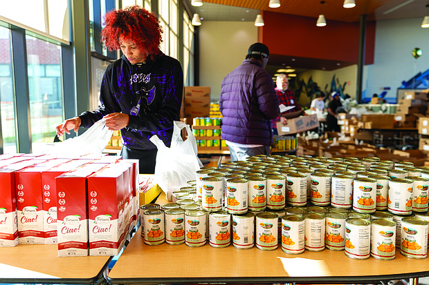 Iliana Davis volunteers at the Holiday Harvest Food Distribution event packing bags of
food in the cafeteria of Martin Luther King Jr. Middle School on Dec. 21.