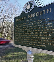A car speeds past a Mississippi Department of Archives and History marker recognizing the legacy of James Meredith in the Civil Rights Movement in Kosciusko, Miss.