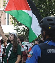 Sereen Haddad, a Virginia Commonwealth University junior, leads a student-organized walkout of at least 100 demonstrators on Oct. 7, 2024, marking the one-year anniversary of Israel’s war against Hamas in Gaza. The walkout, from Monroe Park Campus to the Virginia General Assembly Building, called for action from Virginia lawmakers and VCU leaders.