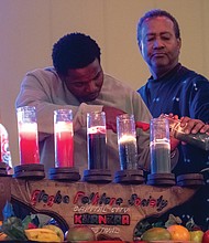 Donnie Seeward of Richmond, center, lights the last candle of the Kinara representing Imani (faith) at the Greater Richmond Convention Center.