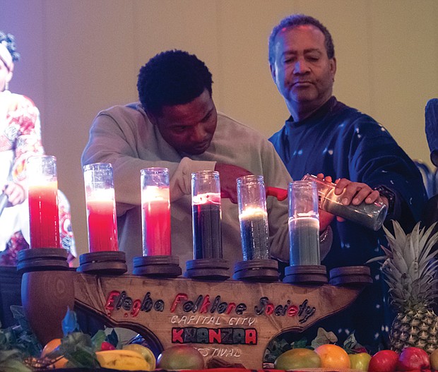 Donnie Seeward of Richmond, center, lights the last candle of the Kinara representing Imani (faith) at the Greater Richmond Convention Center.