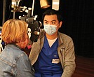 A volunteer at a recent health care event conducts an eye exam.