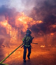 A firefighter battles the Palisades Fire as it burns during a windstorm on the west side of Los Angeles, California, U.S. January 7.
Mandatory Credit:	Ringo Chiu/Reuters via CNN Newsource