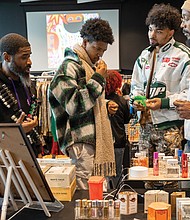 Shoppers browse as Abdul Haqq (left), of Haqq’s Drawer and Kenneth Billups
(right), of Potential Royal Nation, speak with customers.