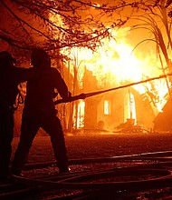 Los Angeles County firefighters spray water on a burning home as the Eaton Fire moved through the area on January 8 in Altadena, California.
Mandatory Credit:	Justin Sullivan/Getty Images via CNN Newsource